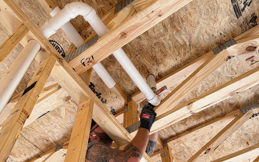 A drain line levelled as it is run through the floor trusses